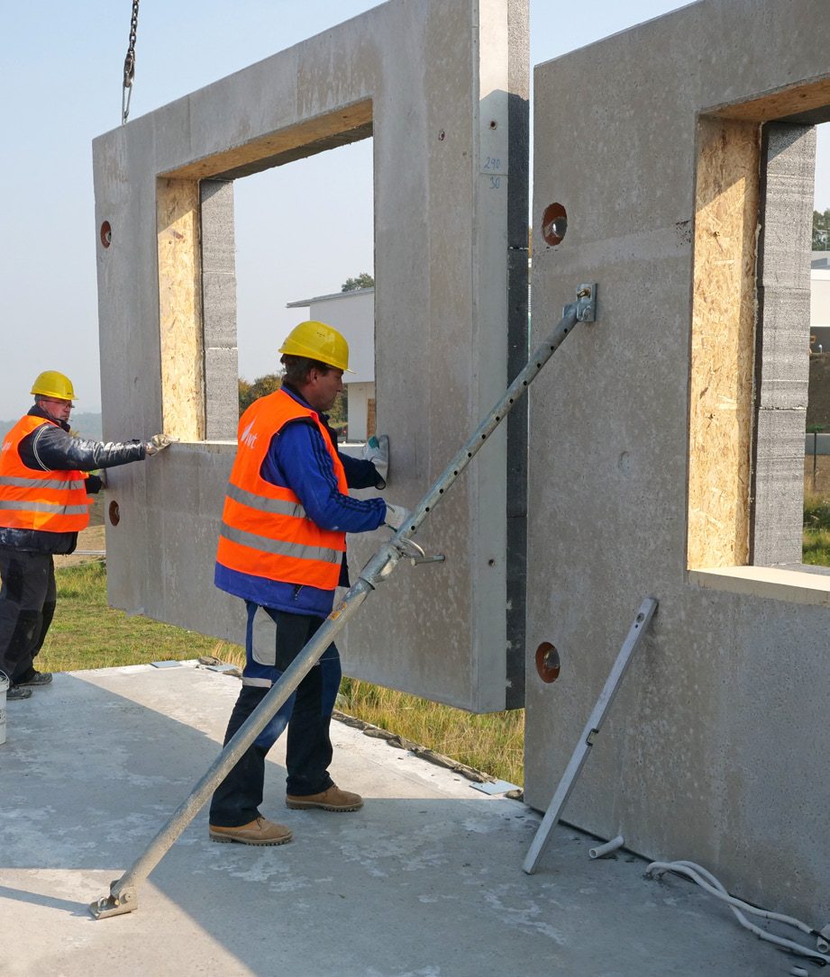 Montážní četa usazuje betonový stěnový panel ALPH na základovou desku